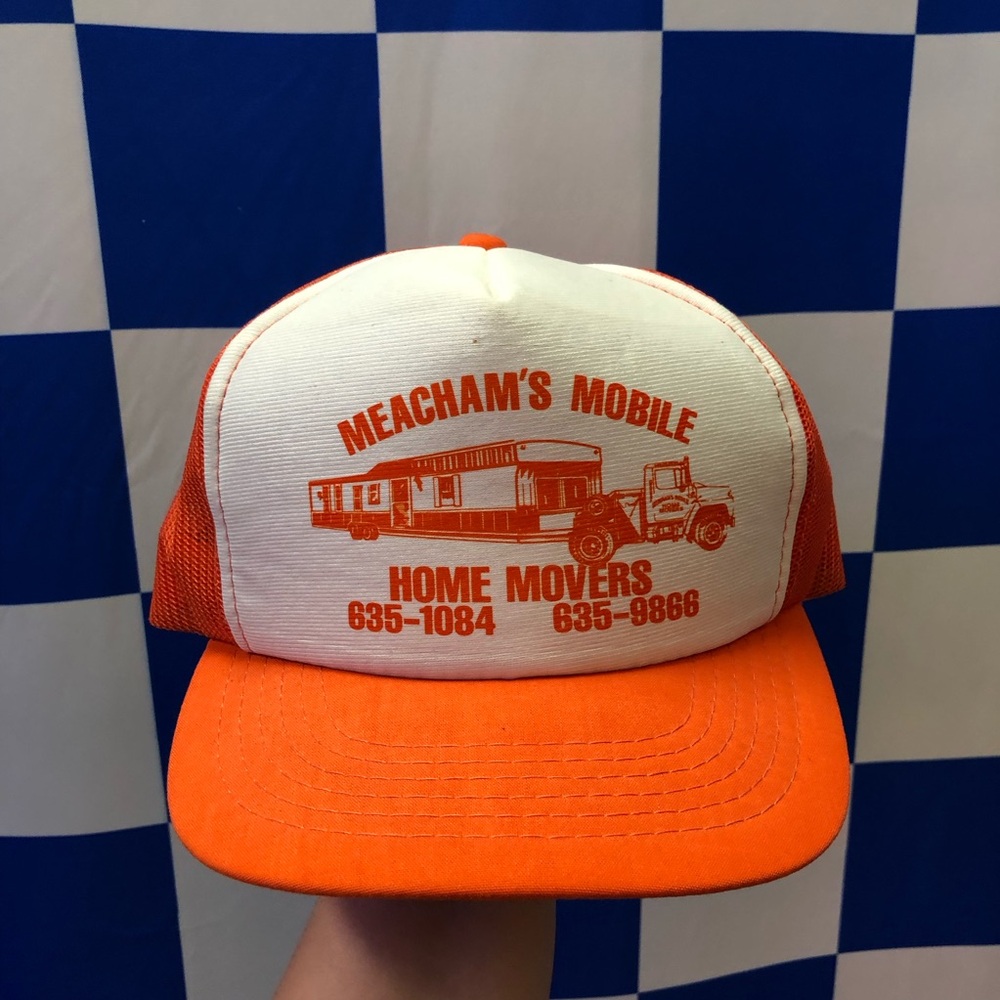 Orange and white vintage trucker with the wording “Meacham’s Mobile Home Movers”